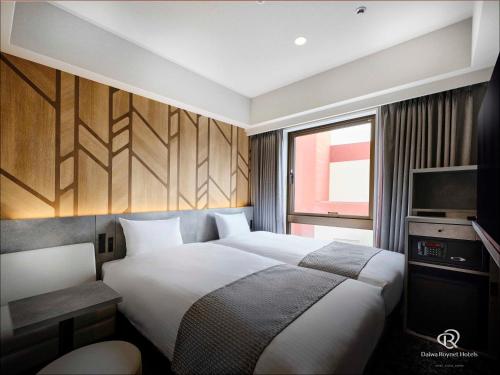 a bedroom with a large bed and a television at DEL style Fukuoka Nishinakasu by Daiwa Roynet Hotel in Fukuoka