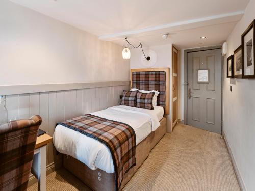 a bedroom with a bed and a desk and a door at Old Court House Inn in Saint Aubin