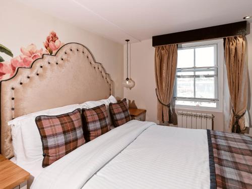 a bedroom with a large white bed with a large window at Old Court House Inn in Saint Aubin