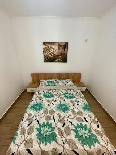 a bedroom with a bed with a floral comforter at Militari Comfort Studio in Roşu