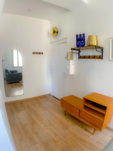 - un salon avec une table et un miroir dans l'établissement Nouveau Appartement L'Authentique Montpellier Centre Ville Proche Gare, à Montpellier