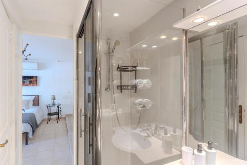 une salle de bain blanche avec une douche et un lavabo dans l'établissement La Porte Du Soleil - Famille - Lac de Saint-Cassien - Calme, à Bagnols-en-Forêt