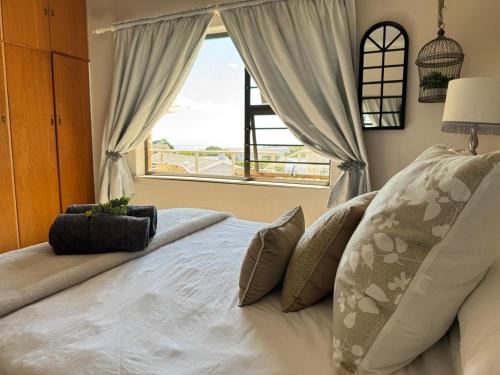 a bedroom with a large bed with a window at Uitsig in Yzerfontein