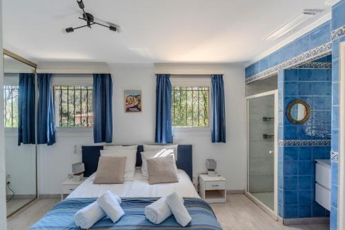 - une chambre bleue et blanche avec un lit et des fenêtres dans l'établissement La Porte Du Soleil - Famille - Lac de Saint-Cassien - Calme, à Bagnols-en-Forêt