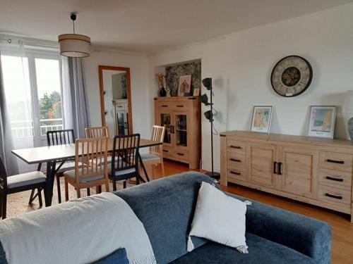 un salon avec un canapé bleu et une salle à manger dans l'établissement Mon appartement vue mer, à Ouistreham