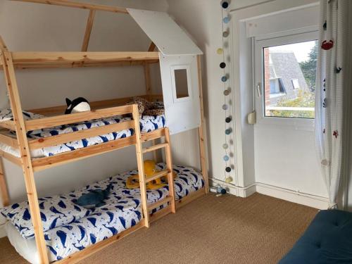 deux lits superposés dans une chambre avec fenêtre dans l'établissement Mon appartement vue mer, à Ouistreham