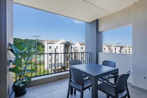 a balcony with a table and chairs and a view of condos at Ballito Village Luxury Apartments in Ballito