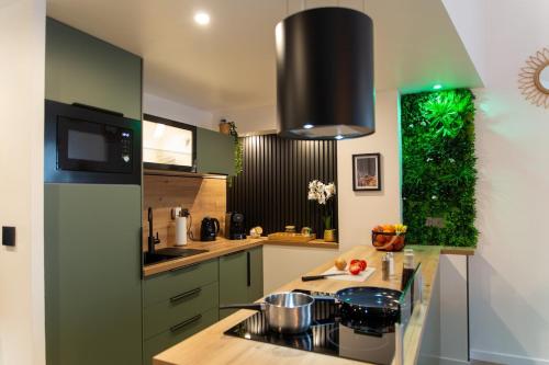 une cuisine avec des placards verts et un comptoir dans l'établissement Dream Factory - Loft & Private Cinema 6P, 8 minutes from Disneyland, à Montry