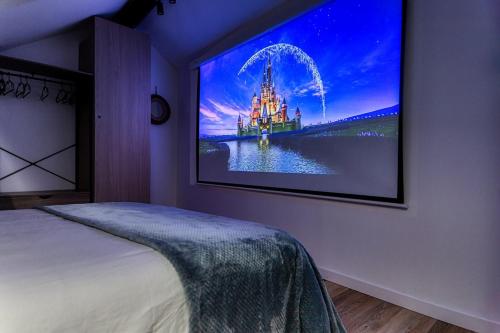 una camera da letto con TV appesa a un muro di Dream Factory - Loft & Private Cinema 6P, 8 minutes from Disneyland a Montry
