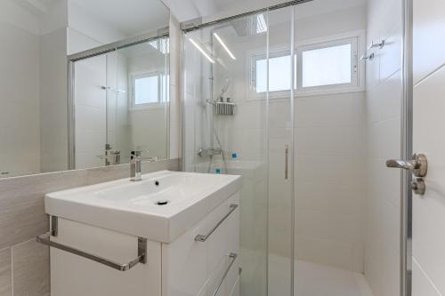a white bathroom with a sink and a shower at Luz de la Luna - Ocean View - Las Americas in Costa de Adeje