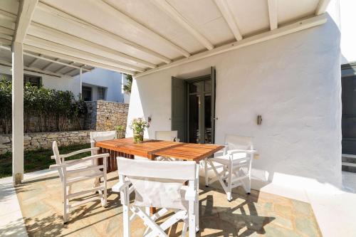 a patio with a wooden table and chairs at Sun Drop II with garden - Drios beach Paros in Drios