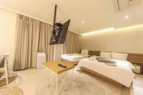 a hotel room with two beds and a flat screen tv at Hotel Yaja Sasang Terminal in Busan