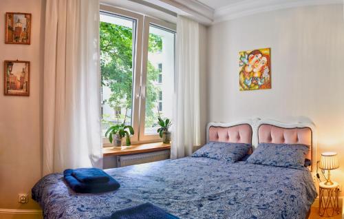 ein Schlafzimmer mit einem blauen Bett und einem Fenster in der Unterkunft Le Petit Okopowa - apartament w centrum Lublina in Lublin