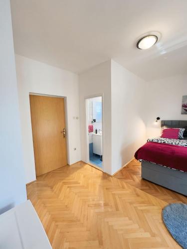 a bedroom with a bed and a wooden floor at Rooms Kate in Krk