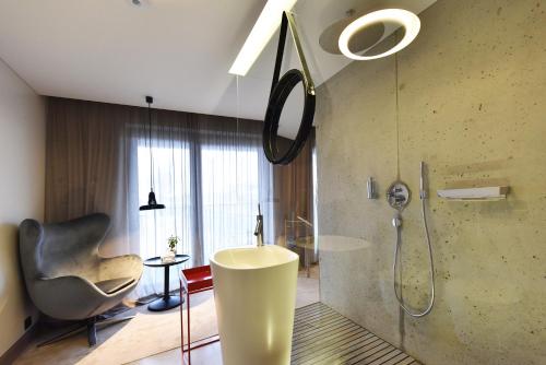 bagno con doccia, lavandino e sedia di Premium Loft Apartment a Palanga
