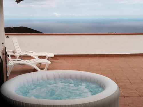a hot tub sitting on a patio with a chair at Los Eucaliptos in Fasnia
