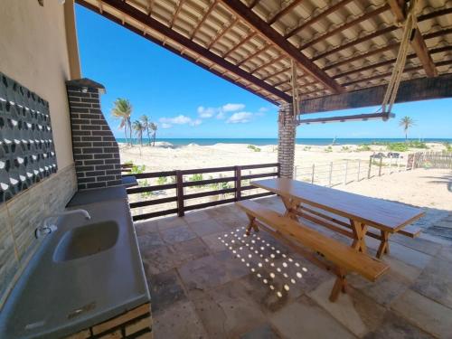 a bathroom with a bench and a sink and the beach at Canto das Ondas in Beberibe