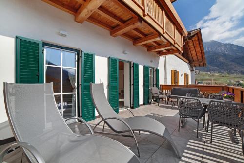 a patio with chairs and tables on a balcony at Engel Appartements Goschtstub in Parcines