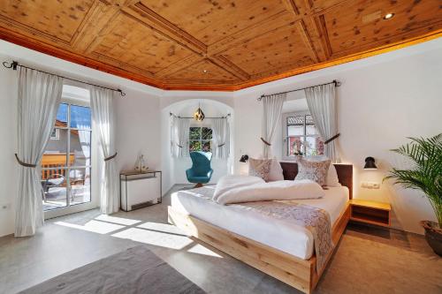 a bedroom with a large bed with a wooden ceiling at Engel Appartements Goschtstub in Parcines