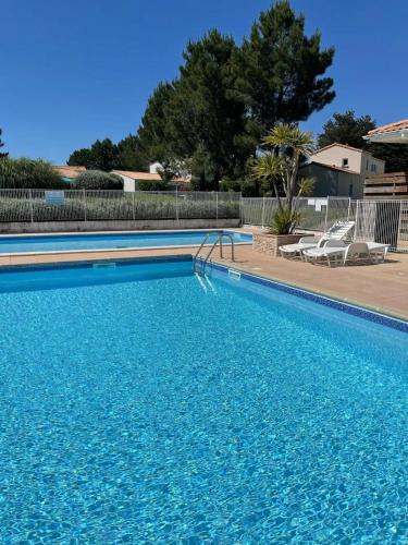 une grande piscine avec de l'eau bleue dans une cour dans l'établissement La cascade-Dolus-2 bedrooms, à Dolus-d'Oléron