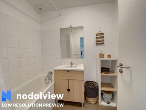 une salle de bain avec un lavabo, une baignoire et un miroir dans l'établissement La cascade-Dolus-2 bedrooms, à Dolus-d'Oléron