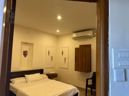 Un dormitorio con una cama y una silla dentro. en GardInn, en Visakhapatnam