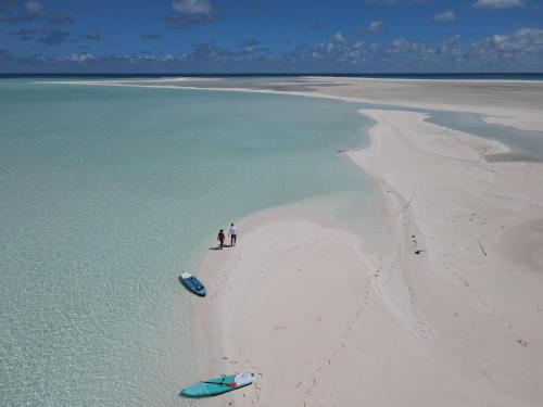 two people standing on a beach with a boat in the water at Catamaran Z'ile cruise in Grand Baie