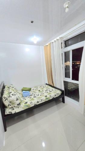 un petit lit dans une chambre avec une fenêtre dans l'établissement Grand View Unit 504 Condo Transient by Dei Gratia, à Baguio