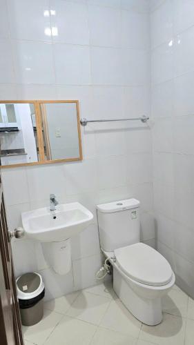 une salle de bains blanche avec toilettes et lavabo dans l'établissement Grand View Unit 504 Condo Transient by Dei Gratia, à Baguio