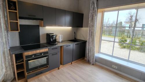 a kitchen with black cabinets and a large window at Sakala holiday home with sauna in Viljandi