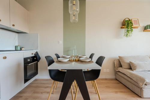 une salle à manger avec une table et des chaises blanches dans l'établissement Cocooning à 5 mn de la Grande Plage Parking privé, à Les Sables-dʼOlonne