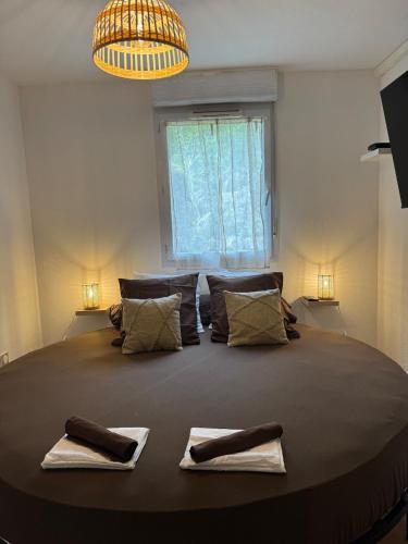 una camera da letto con un letto grande con due asciugamani sopra di T2, Balneo, sauna, lit rond, jeux arcades, parking a Tournefeuille