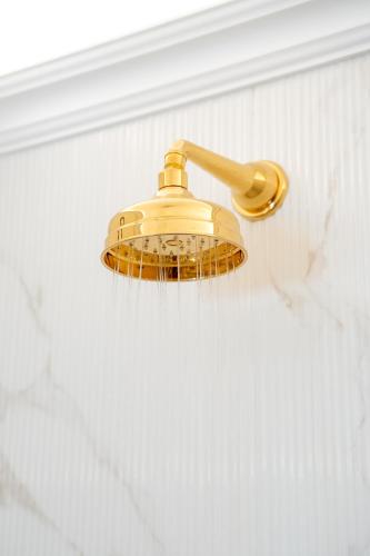 a bathroom shower with a gold shower head at La Sirenetta Luxury Suite Positano in Positano