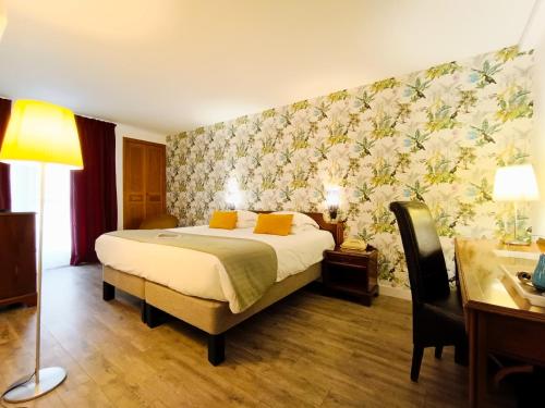 - une chambre avec un lit et un mur orné de fleurs dans l'établissement Hotel Des Tuileries, à Nîmes