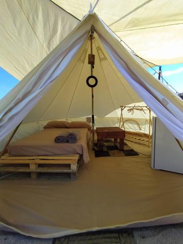 a tent with a bed and a table in it at Camping B&B La Contea in SantʼAnna Arresi