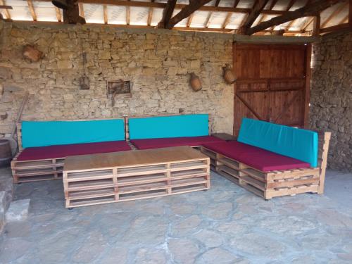 a room with blue and red benches and a stone wall at Vedra Guest House in Ganchovets