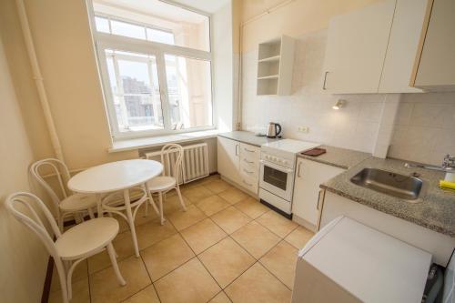 a kitchen with a table and chairs and a sink at Cheap Apartments in Kyiv