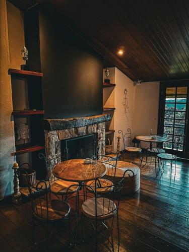 a room with tables and chairs and a fireplace at Smart Hotel Reserva Campos do Jordão in Campos do Jordão