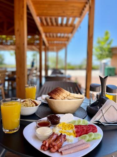 a table with a plate of breakfast food on it at Kamberi Hotel & Apartments in Velipojë
