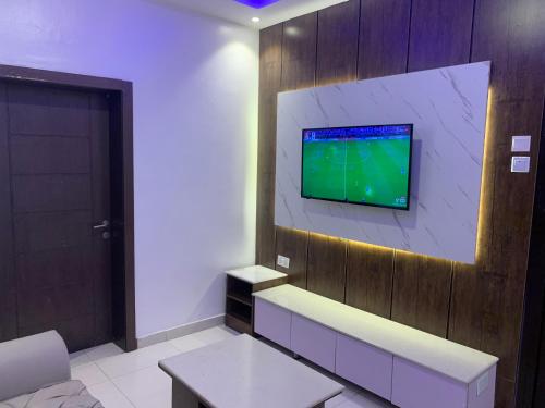 a living room with a tv on a wall at Presken Hotel @Oniru in Lagos