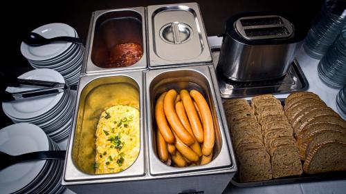 a table topped with containers of food and bread at Hotel Zimní stadion Náchod in Náchod