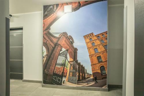 a mural of a building in a hallway at WiguryTower Apartaments 71' in Łódź