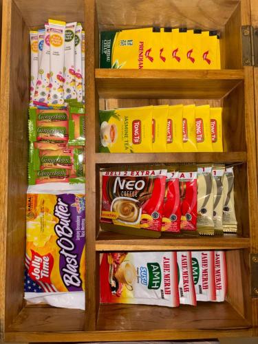 a cabinet filled with different types of food and drinks at Cozy Botanical Garden House in Batam Center