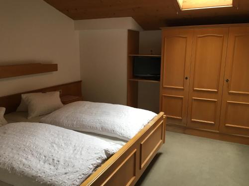 a bedroom with a large bed and a cabinet at Hubergut Appartements in Radstadt