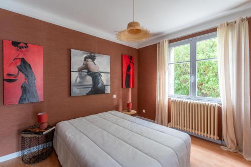 a bedroom with a large bed and paintings on the wall at Vacances révées au Pin Parasol in Le Thor