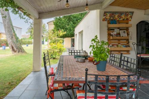 a table and chairs on a porch with a table at Vacances révées au Pin Parasol in Le Thor