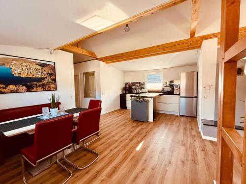 a living room with a table and chairs and a kitchen at Fabians Ferienhaus - Rurseeloft in Simmerath