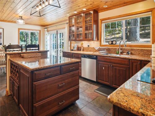 une grande cuisine avec des placards en bois et des comptoirs en granit. dans l'établissement High Sierra Escape - Cozy, Spacious Mountain Home, à South Lake Tahoe