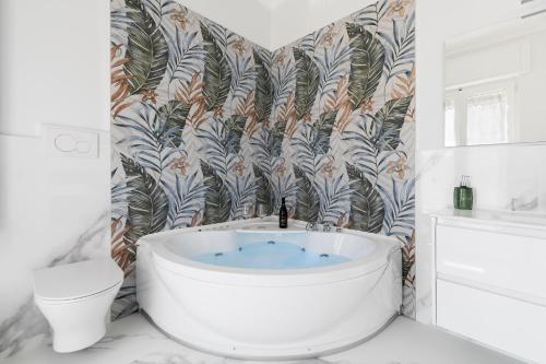 a bathroom with a bath tub and a toilet at House White Puglia by BarbarHouse in Fasano