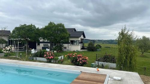 une maison avec une piscine devant une maison dans l'établissement Villa spacieuse avec piscine au milieu des vignes, à Sainte-Croix-du-Mont